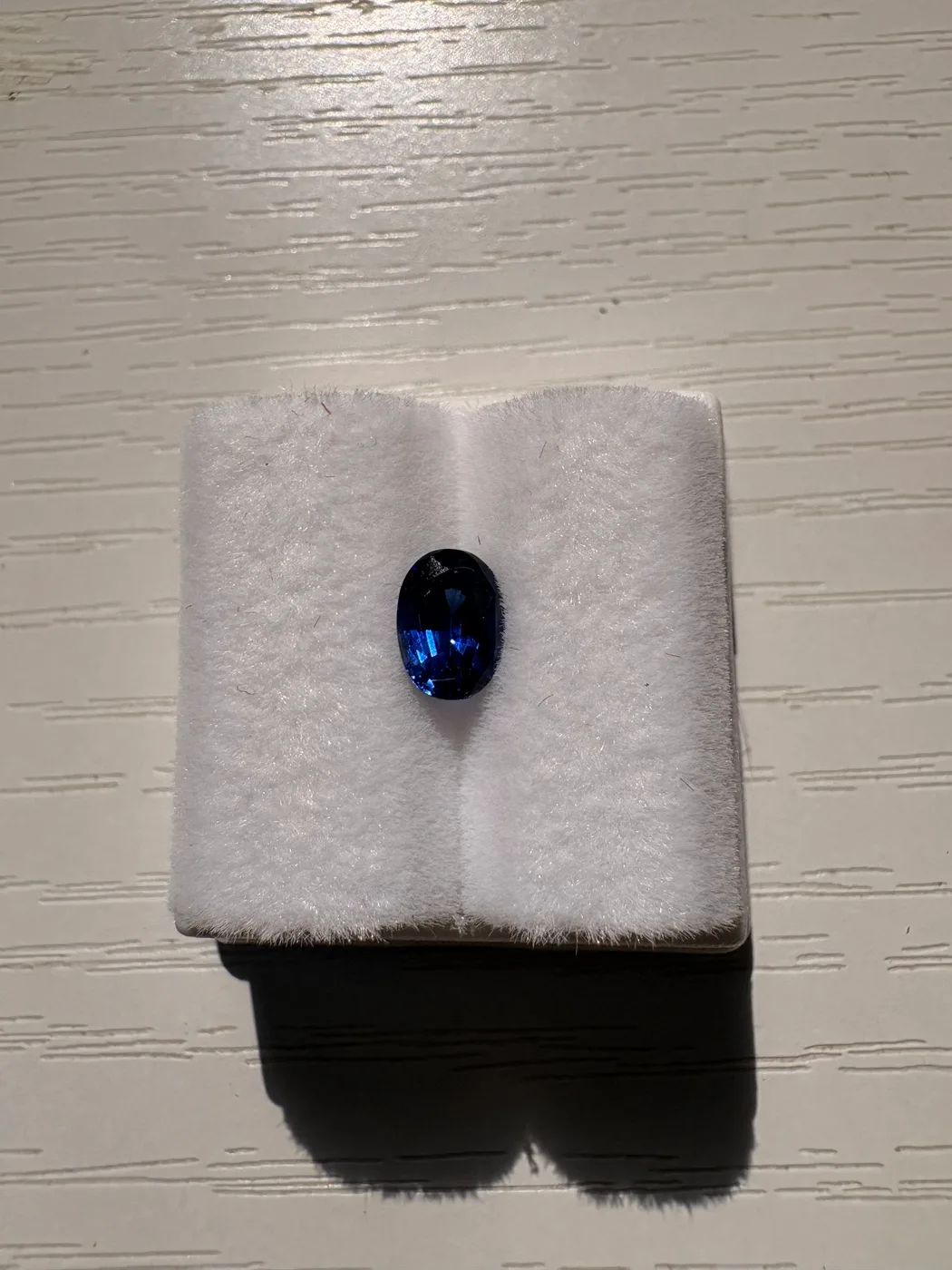 Front view of serial 110 oval Sri Lankan blue sapphire in a display tray