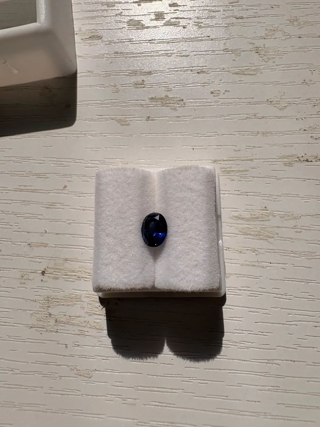 Front view of serial 111 oval Sri Lankan blue sapphire in a display tray