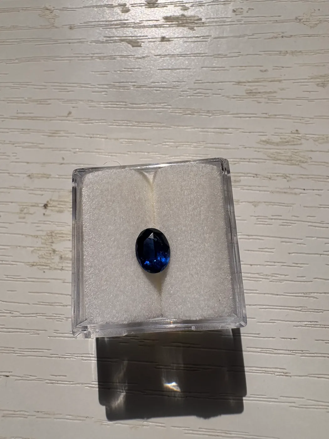 Front view of serial 112 oval Sri Lankan blue sapphire in a display box