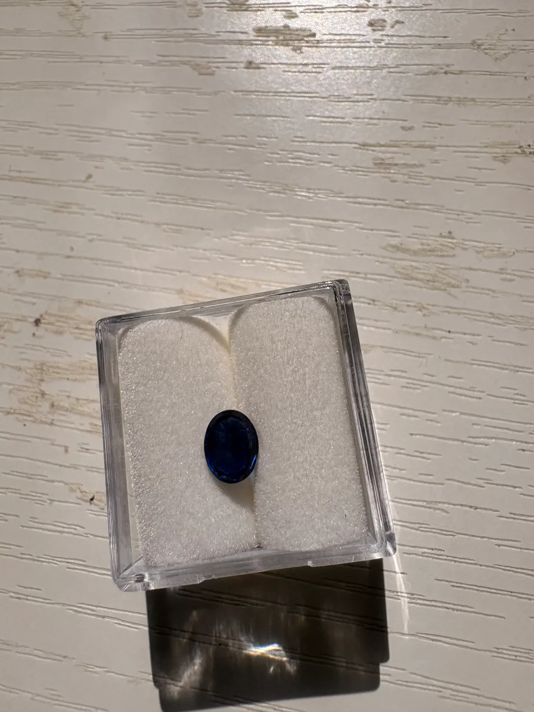 Alternate front view of serial 112 oval Sri Lankan blue sapphire in a display box