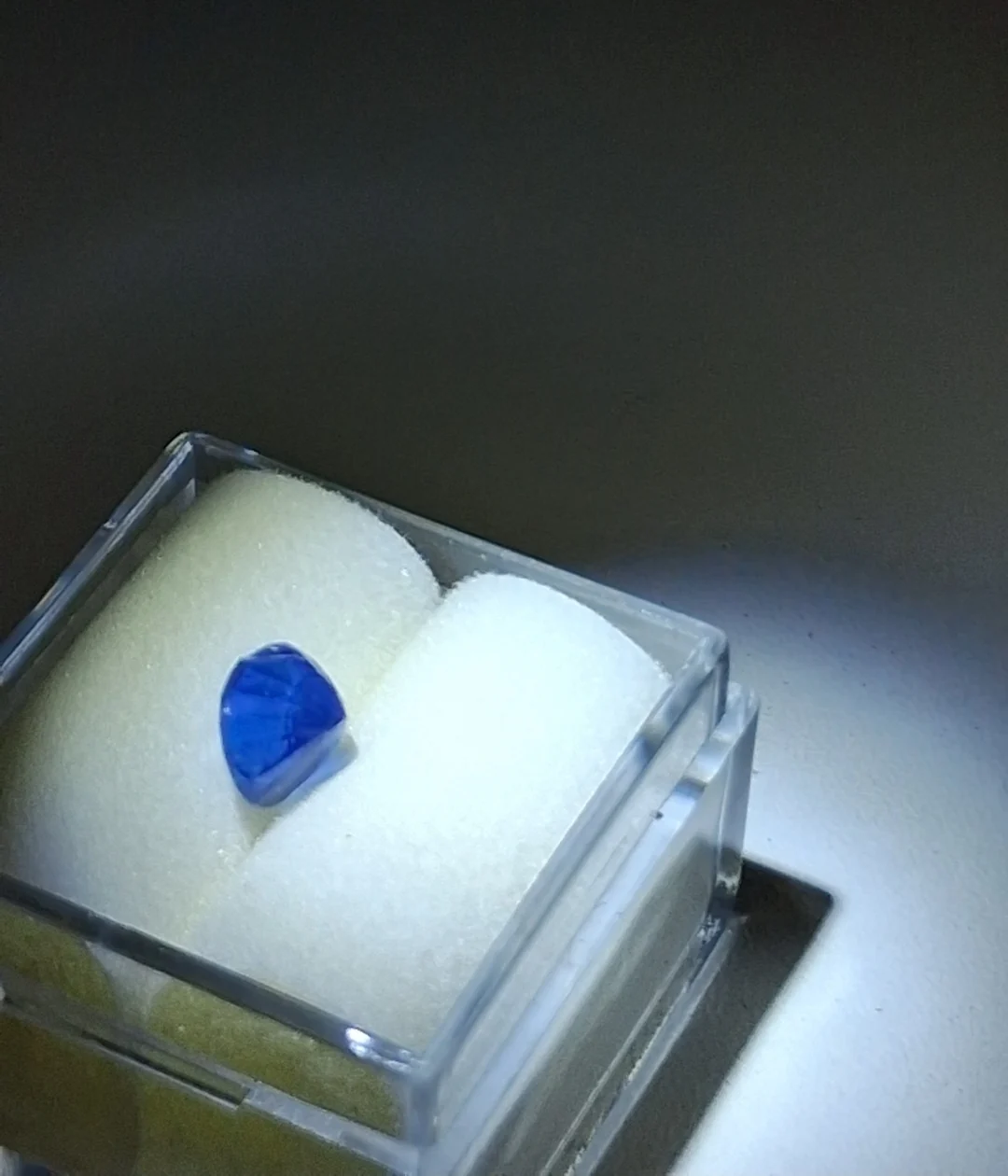 Side view of the oval blue sapphire in its display box