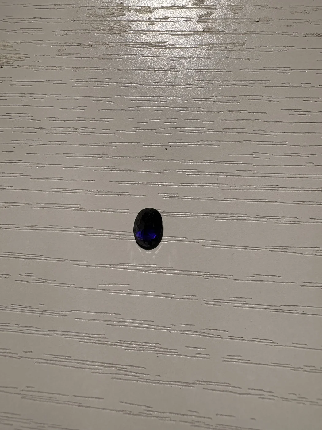 Serial 105 violetish-blue oval Sri Lankan sapphire under light